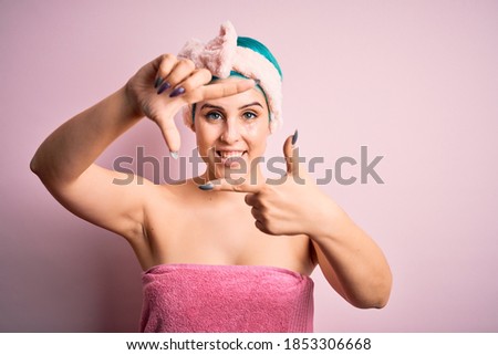 Young woman with blue fashion hair wearing beauty facial mask over pink isolated background smiling making frame with hands and fingers with happy face. Creativity and photography concept.
