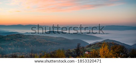panorama of mountains in the fog at sunrise. autumn season