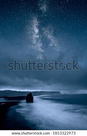 Ocean and coastline at night against starry sky