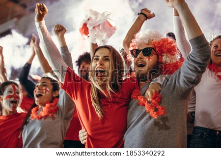 Excited sports fans at live game chanting and cheering for their team. Young people watching football match chanting to cheer English national team. Royalty-Free Stock Photo #1853340292
