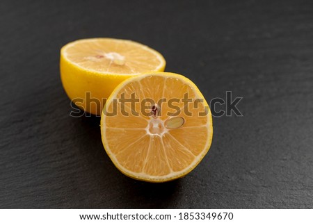 Close-up cut lemon on black stone background