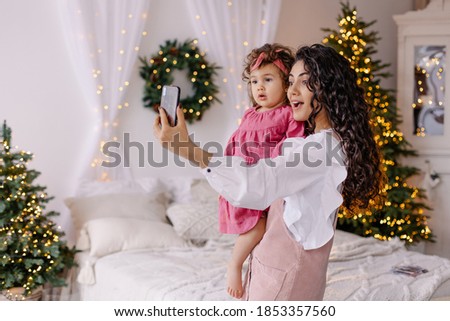Mother and daughter make a selfie. Family wishes each other a Merry Christmas online. Virtual communication new year 2021. Lockdown distance quarantine. Pandemic covid-19 the new normal.  Emotional