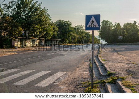  zebra crossings crosswalk with traffic sign "pedestrian crossing" on an empty road
