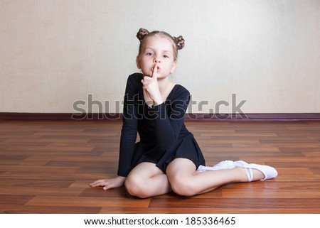 little girl gymnast sitting on the floor