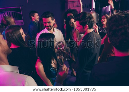 Photo portrait of people drinking champagne together at posh nightclub in neon lights