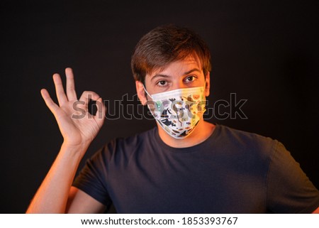 A young man wearing a face mask with a message to wear a mask to stop the spread of Covid-19