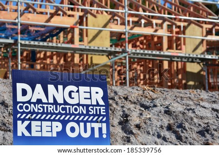 Danger contraction keep out site sign in a new home construction site. Concept photo of Building a new home,mortgage, finance, economy, market, construction work, health and safety.