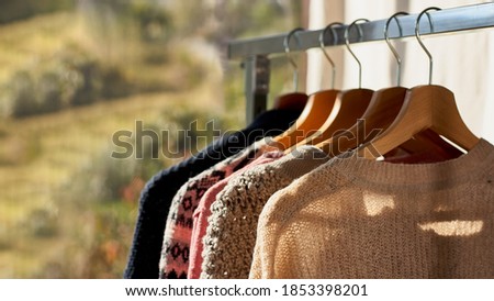 Autumn winter season knitwear.Colorful warm knitted sweaters with different knitting patterns on hanger open clothes rail