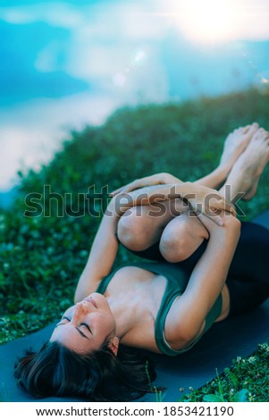 Yoga Woman by The Water. Wind Relieving Pose.