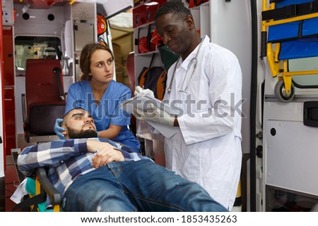 Emergency doctor asking patient to sign in logbook at ambulance car