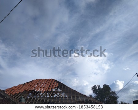 
old home improvement process, new tile roof, 
partly not installed, the cloudy background is a sign of heavy rain