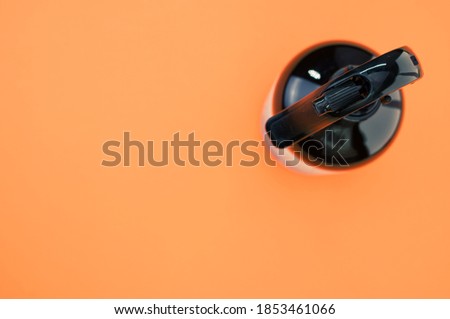 A high angle shot of a plastic spray bottle isolated on an orange background