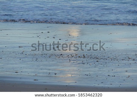 Waves and reflections on the sea and sand