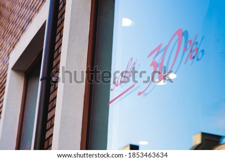 Sale sign on glass window, showcase of shop. Discount and sale concept, shopping.