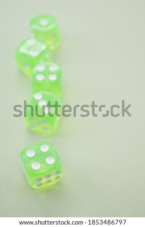 A top view closeup of five neon green dice isolated on a grey background