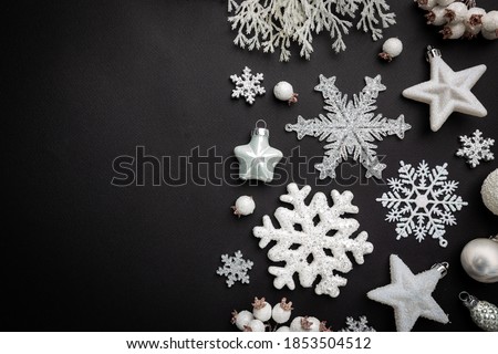 Christmas holidays composition with white christmas decorations and snowflakes on black background with copy space for your text