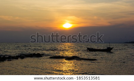 Silhouette of a fishing boat in the right of the picture, in the evening there is a sunset on the sea
