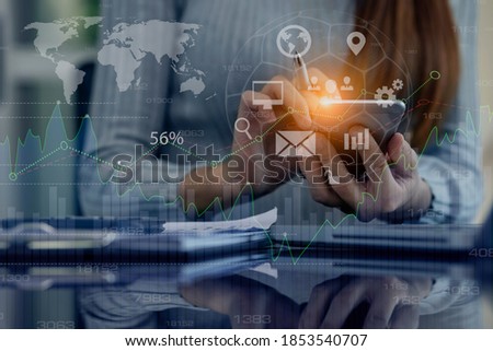 Double exposure of businesswoman hands using smartphone and laptop computer with virtual diagram, graph interfaces icons, Technology digital and stock market concept, Blurred background.