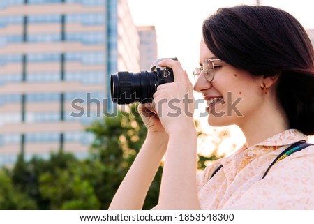 young traveler woman taking a photo with a camera, concept of youth and creative lifestyle, copy space for text