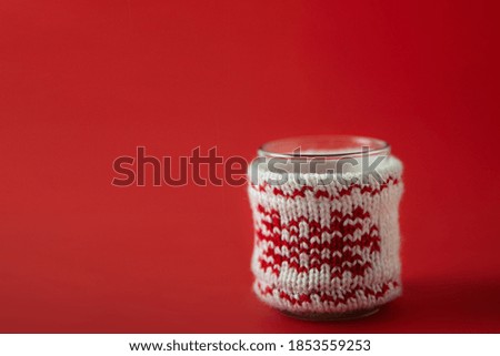 Christmas candlestick in handmade decor on a red background