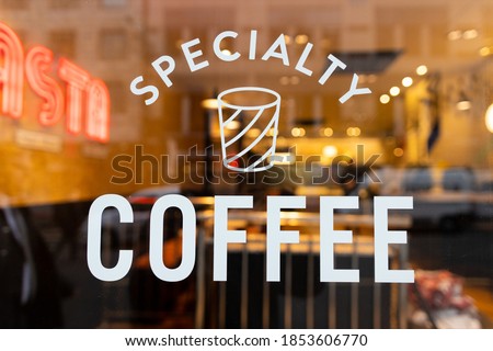 A restaurant window with a Specialty Coffee sign on it Royalty-Free Stock Photo #1853606770