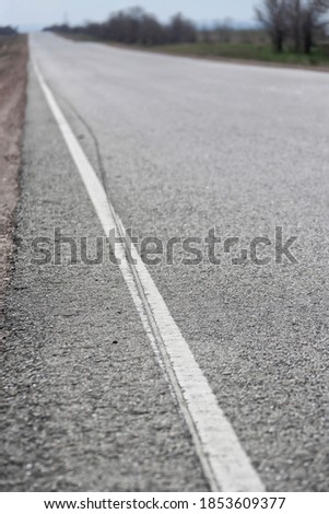 Asphalt road in a rural area. Road markings. Selective focus. Shallow depth of field