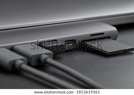 Close-up photo of type-c hub with cables and SD card connected to laptop