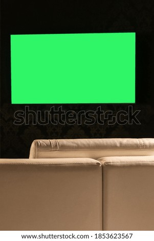 Green TV screen on the background of the sofa close-up.