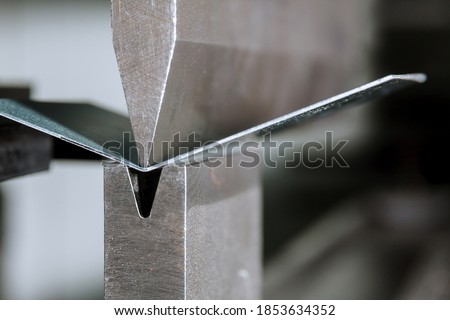 The process of bending sheet metal on a hydraulic bending machine Royalty-Free Stock Photo #1853634352