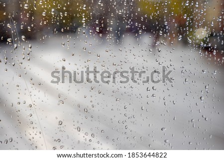 Selective focus of raindrop on window in cloudy and rainy day, Water drops with blurred background, Condensation on glass texture, Nature water pattern.