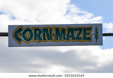 Corn maze sign over cloudy sky