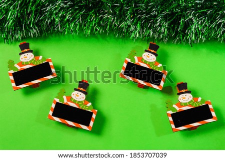 green christmas background with bell, candle, gift box, little snow man