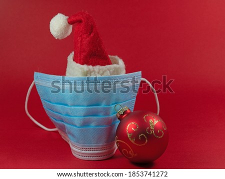 Santa Claus hat with face mask against red background