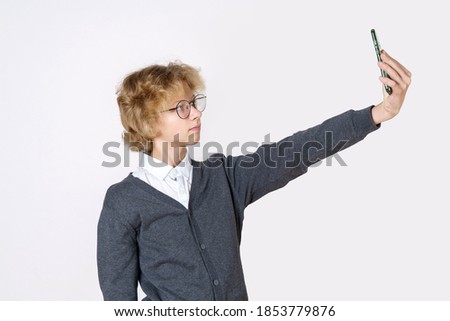 Education concept. Teen boy making selfie by smartphone. Isolated over white background.