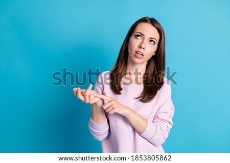 Photo of cute unsure young lady look up empty space counting fingers roll eyes up summarizing months persuade bank cancel house credit debt wear violet pullover isolated blue color background