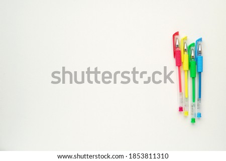White background with colorful gel pens, empty desk mockup for coloring page, planner, kids activity, art or back to school concept, empty space for text.  