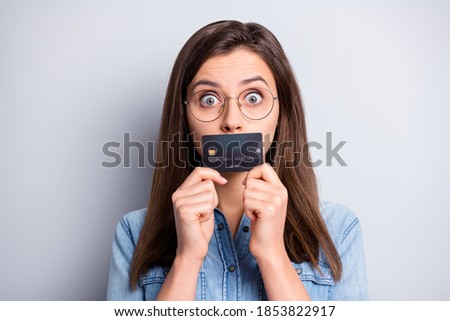 Close up portrait of nervous person cover mouth bank card spend too much isolated on grey color background