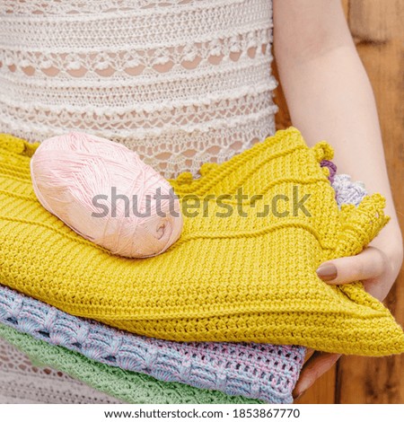 Woman holding stack of knitted things. Crochet hobby concept