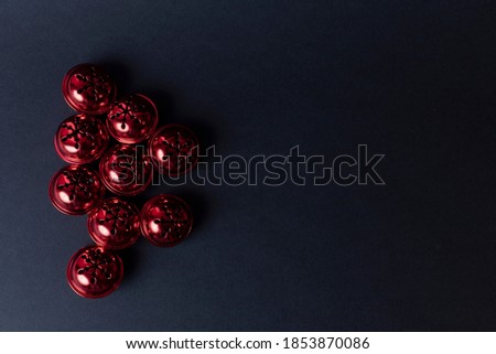 Top view of red sleigh bells on black dark background