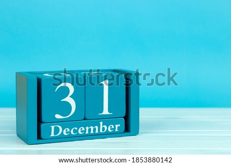 wooden calendar with the date of December 31 on a blue wooden background