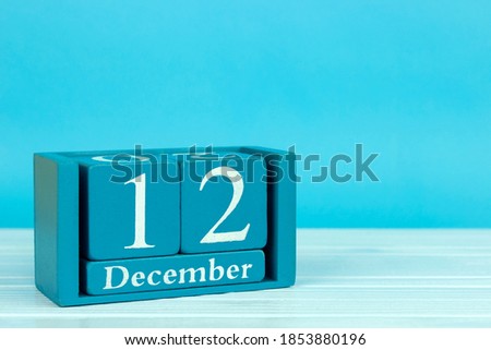 wooden calendar with the date of December 12 on a blue wooden background, 
World Universal Health Day; International Day of Neutrality