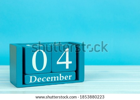 wooden calendar with the date of December 4 on a blue wooden background, 
International Cheetah Day; Day of ordering gifts to Santa Claus