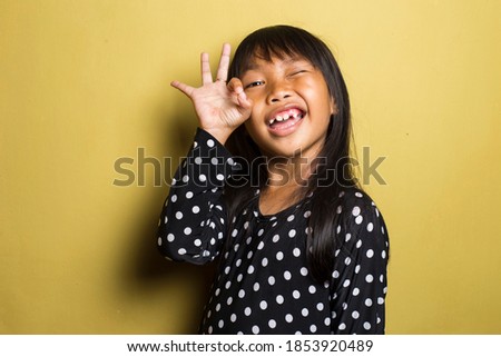 asian little girl showing a OK hand sign.	