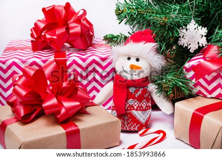 On the table are wrapped Christmas gifts, a Christmas tree, a snowman, a lollipop. Christmas and New Year concept.