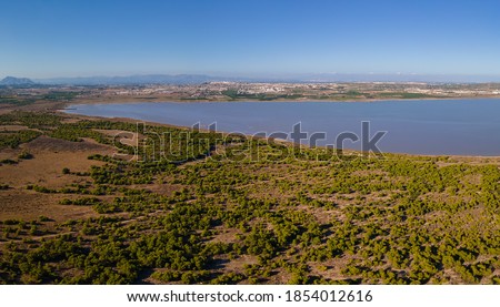The western part of the La Mata lagoon north of the Spanish city of Torrevieja. The city of Montesinos can be seen in the background. Mountains are on the horizon.