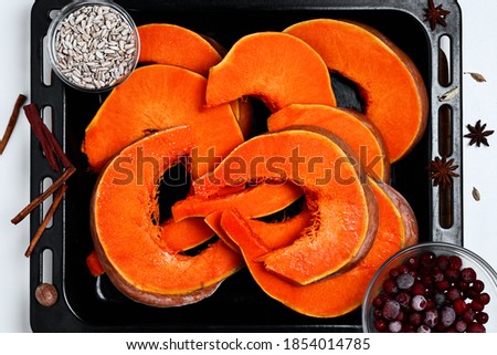 Pumpkin cut into slices on a baking sheet, preparation of a roasting dish, layout. Roasting pumpkin northern cuisine. Autumn harvesting. Top view
