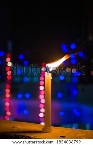 A candle burning on the roof , on occasion of Diwali, With Jhalars(Rope Lights) in blur Bokeh effect.