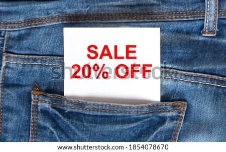 Text Sale 20 off on white paper in the pocket of blue denim jeans. Can be use as marketing concept