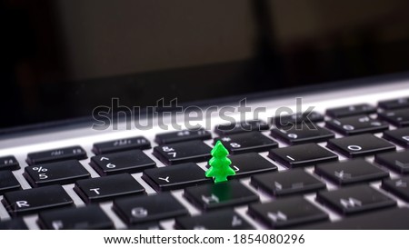 Christmas tree and keyboard.Small green plant growing from black computer keyboard.Technology with holiday nature concept