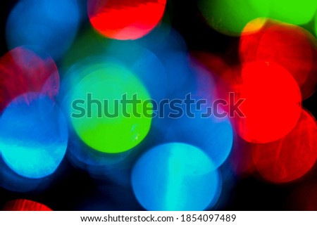 Colorful Bokeh lights from festive garlands. New Year's background. Bright Christmas lights. Colorful abstract background. Blurred and luminous lights. Bokeh effect from lighting spots.